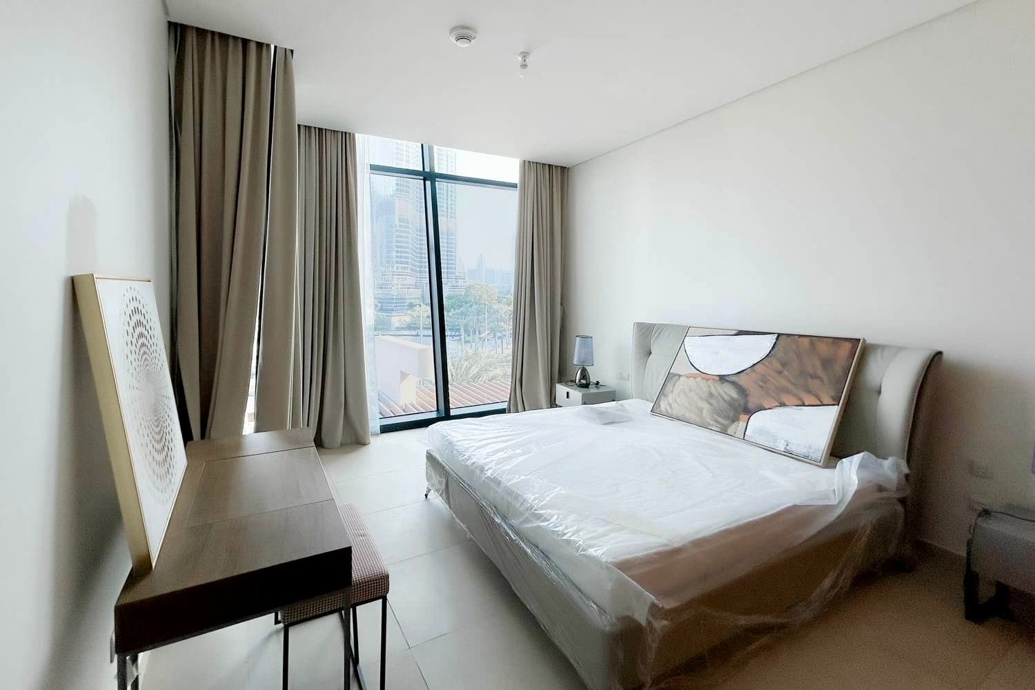 Private bedroom with king bed, throw and balcony at Burj Vista